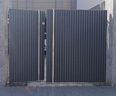 an open gate on the side of a building that has been constructed with metal slats