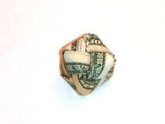 a money origami ball made out of one hundred dollar bills on a white background