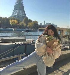 a woman holding flowers near the eiffel tower