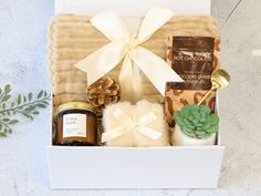 a gift box filled with candles, cookies and other items