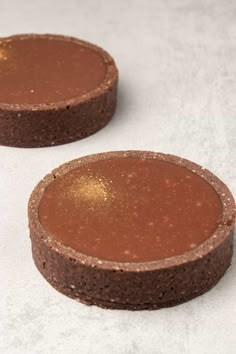 two brown cakes sitting on top of a white table