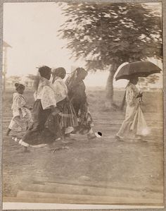 an old black and white photo of people with umbrellas