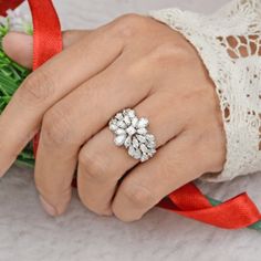 a close up of a person's hand wearing a ring with flowers on it