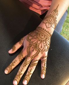 a woman's hand with henna tattoos on it