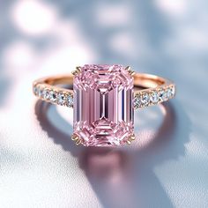 The Elisa: Classic Beauty The Elisa ring is a breathtaking display of beauty, featuring a stunning emerald-cut moissanite center stone in a striking pink hue. This exquisite piece is designed to captivate attention with its vibrant color and flawless sparkle, offering a luxurious alternative to traditional diamonds at an unbeatable value. The stone is set in a rose gold vermeil band, enhancing the overall brilliance and ensuring lasting durability. Crafted to perfection, The Elisa is true to U.S