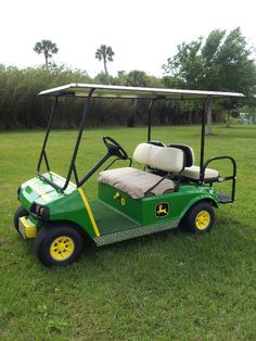 a green golf cart parked in the grass