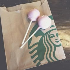 two lollipops sitting on top of a starbucks bag