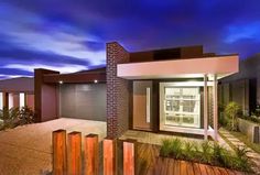 a modern home at night with blue sky in the background