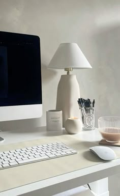 a white desk with a computer, keyboard and mouse on it in front of a window