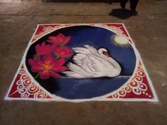 a white swan with red flowers in its beak and on the ground is a painting