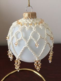 a white ornament hanging from a gold ring