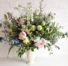 a white vase filled with lots of flowers