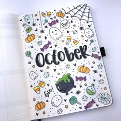 an open notebook with the word october written in black on it and lots of halloween decorations