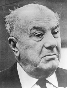 an old black and white photo of a man in suit and tie looking off to the side