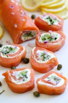 there are many small appetizers on the plate with lemons and capers