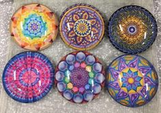 six colorful glass plates sitting on top of a table