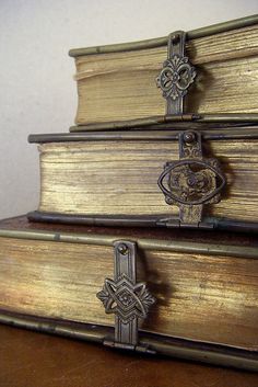 three old books stacked on top of each other with ornate metal handles and cross decorations