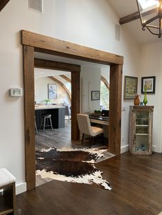 an open door leading into a living room with cow hide rugs on the floor