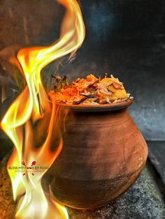 a pot filled with food sitting on top of a table covered in fire and flames