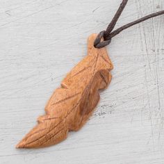 a wooden leaf is hanging on a string with a cord attached to the back of it