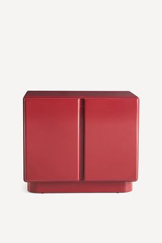 a red cabinet sitting on top of a white wall