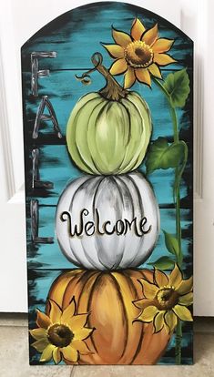 a painted welcome sign with pumpkins and sunflowers