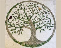 a tree with two birds sitting on it's branches and leaves in the shape of a circle