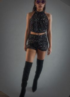 Sparkling two-piece set is the ultimate rave or festival outfit. The sparkling sequin top pairs perfectly with the matching high-waisted shorts, both designed to move with you as you dance the night away. The shimmery fabric catches the light, making you the star of the show. It's fun, flirty, and perfect for those high-energy nights. Just add some bold accessories and glitter, and you're ready to shine under the festival lights! Sequin Shorts For Night Out And Party Season, Fitted Short Length Crop Top For Night Out, Fitted Short-length Crop Top For Night Out, Disco Style Shorts For Night Out, Glamorous Party Shorts, Black Rave Party Bottoms, Fitted Disco Shorts For Club, Disco Club Shorts Fitted Style, Disco Style Fitted Shorts For Club