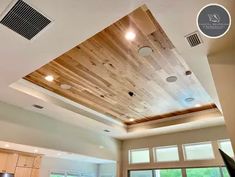 a kitchen with wooden ceiling and white walls