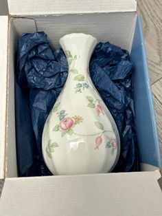 a white vase sitting inside of a box