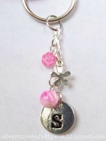 a silver key chain with pink beads hanging from it's end and the letter b on top