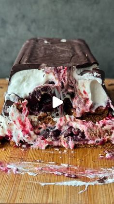 an ice cream sandwich is cut in half on a cutting board with chocolate and cherries