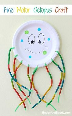 a paper plate with some colorful sticks attached to it and a face drawn on it