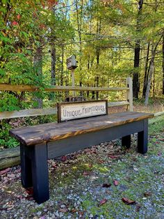 a wooden bench with a sign on it in the woods