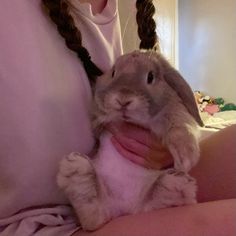 a woman holding a rabbit in her arms