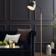 an elegant living room with black walls, gold accents and a blue velvet sofa in the corner