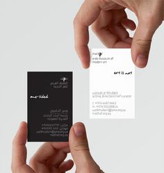 two hands holding business cards in front of each other