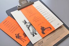 an orange and black clipboard with some papers attached to it