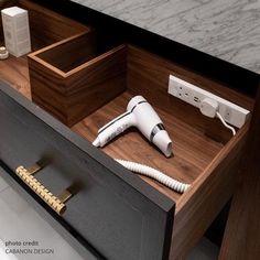 a hair dryer sitting on top of a wooden drawer