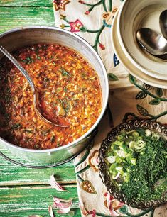 a pot filled with stew next to a spoon