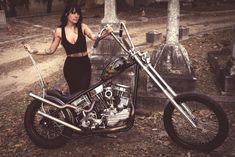 a woman standing next to a parked motorcycle