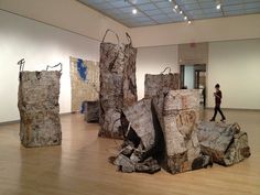 several pieces of wood sitting on top of a hard wood floor in an art gallery