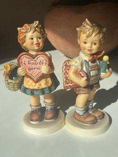 two little figurines are standing next to each other