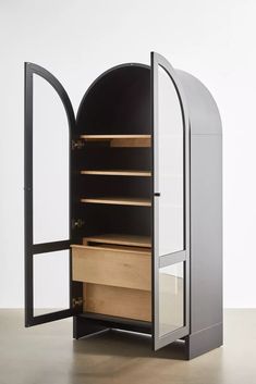 an open black and white cabinet with wooden drawers