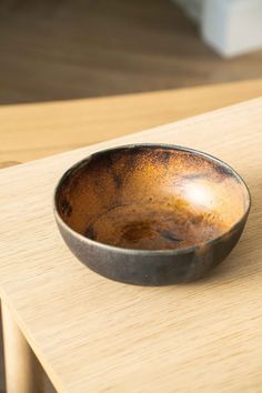 a brown bowl sitting on top of a wooden table