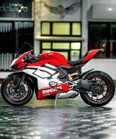 a red and white motorcycle parked in front of a building