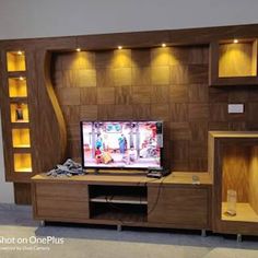 an entertainment center with built in shelving and lighting