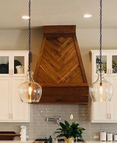 a kitchen with two hanging lights over the stove