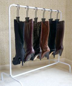 four pairs of boots are hanging on a rack