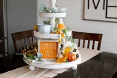 a three tiered cake sitting on top of a wooden table next to a sign